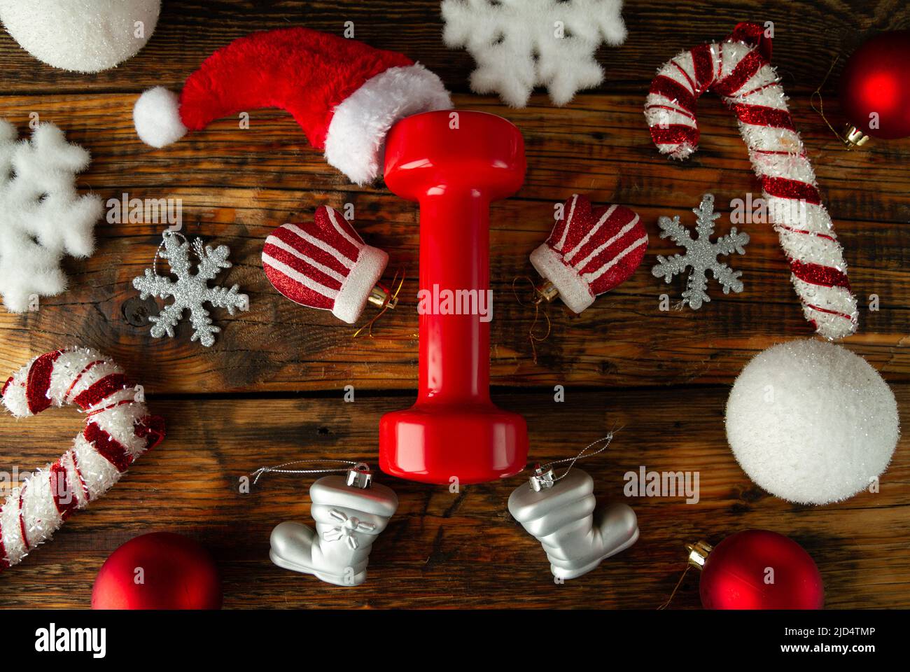 Rote Turnhantel, stilisiert als Weihnachtsmann. Hut oben. Hände, Beine mit Handschuh angeordnet, Stiefel Weihnachtsschmuck. Gesunde Fitness Urlaubskonzept. Stockfoto