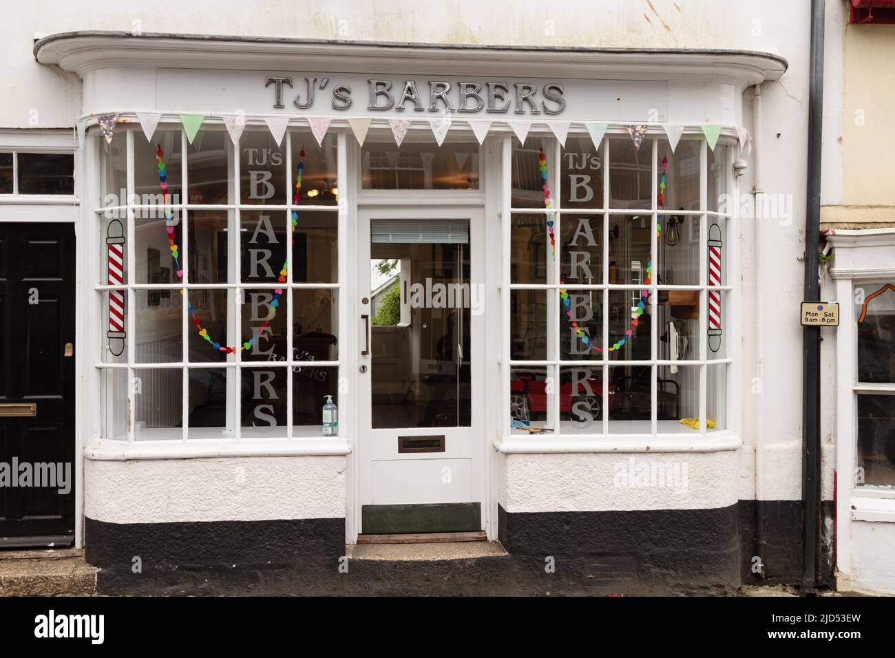 Einzelhandelsgeschäfte (TJ's Barbers) in der Meneage Street, Helston, Cornwall, England Stockfoto