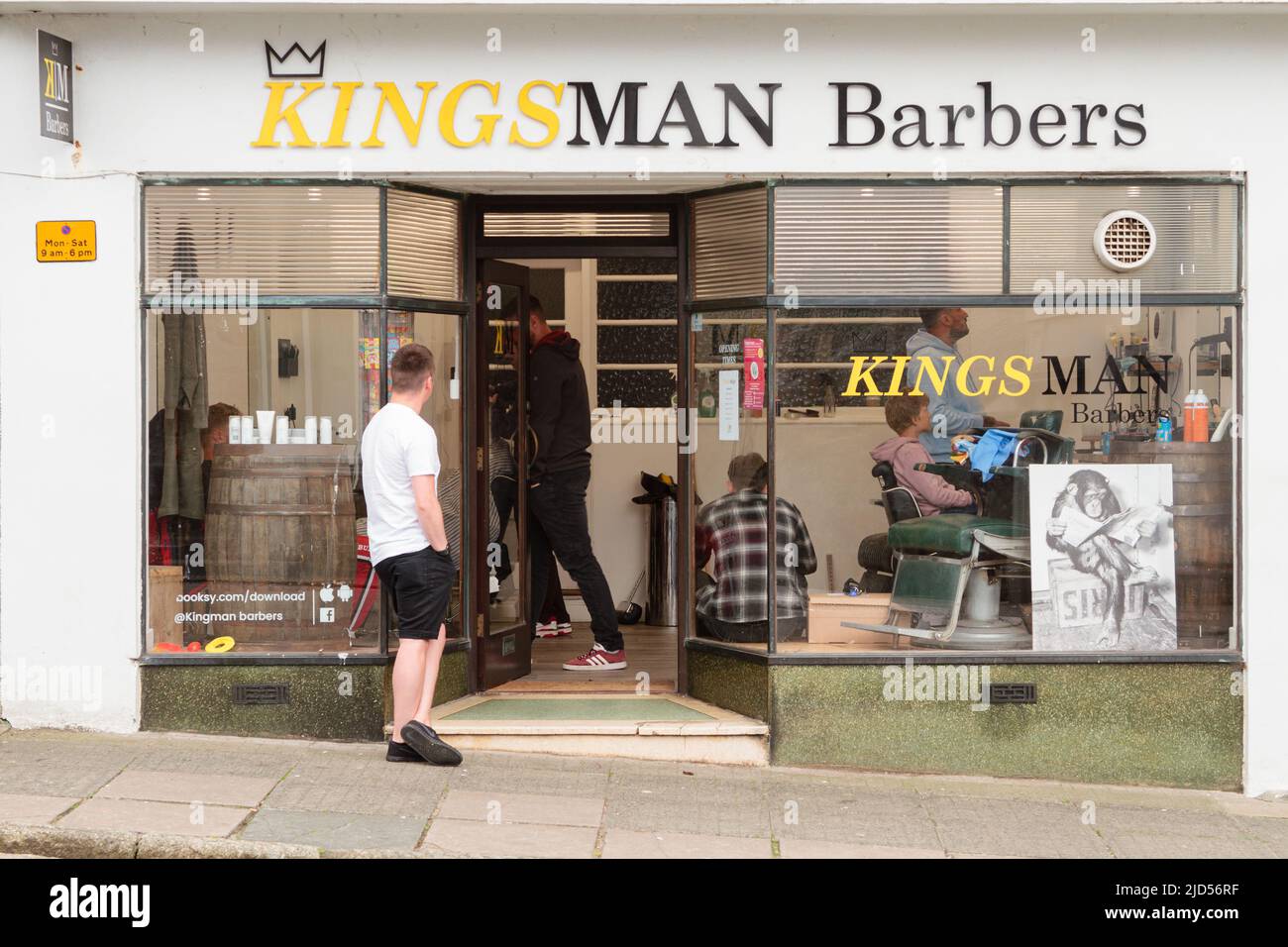 Einzelhandelsgeschäfte (Kingsman Barber) in der Coinagehall Street, Helston, Cornwall, England Stockfoto