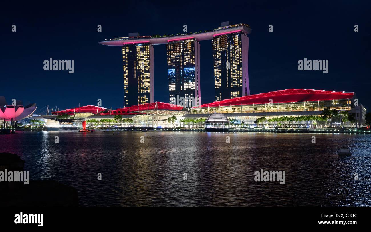 Singapur, Singapur. 14.. Juni 2022. Bunt beleuchtet ist das Marina Bay Sands Resort in Singapur. Das 2010 eröffnete Hotel verfügt über ein Casino, ein Einkaufszentrum, zwei Theater, ein 120.000 Quadratmeter großes Veranstaltungszentrum und zahlreiche Restaurants. Quelle: Bernd von Jutrczenka/dpa/Alamy Live News Stockfoto