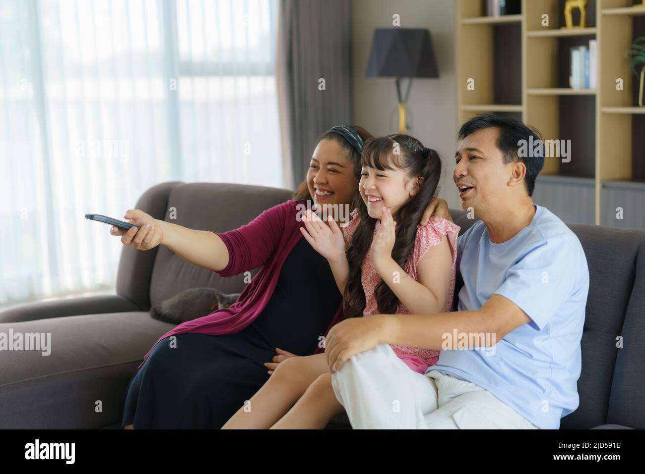 Glückliche asiatische Familie mit Vater, Mutter und Tochter genießen Wochenendaktivitäten verbringen mehr Zeit zu Hause und damit wahrscheinlich mehr Zeit vor dem Stockfoto
