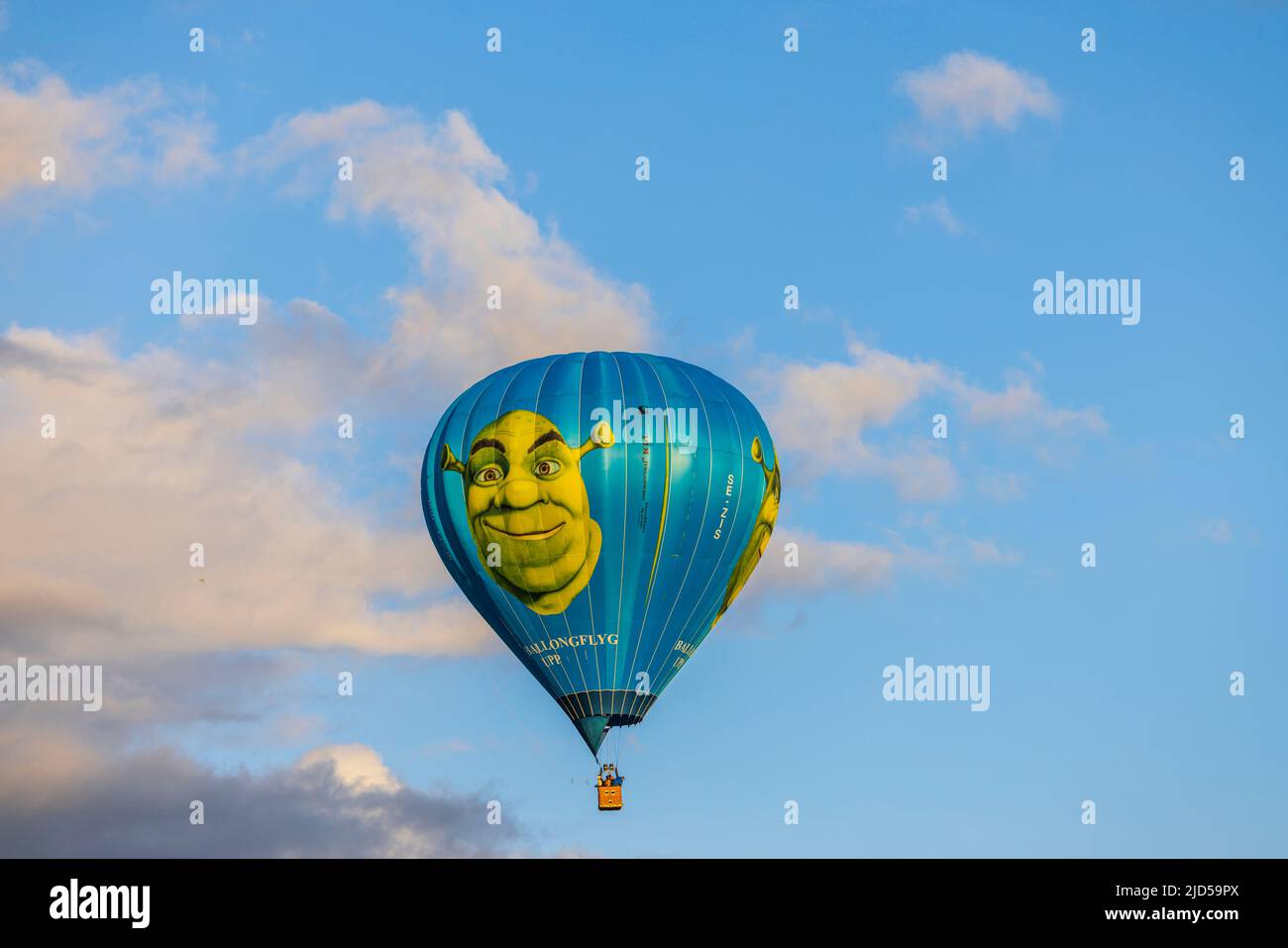 Schöne Aussicht auf Menschen, die in Shrek Heißluftballon weit weg in blauem Himmel mit weißen Wolken fliegen. Schweden. Uppsals. Stockfoto