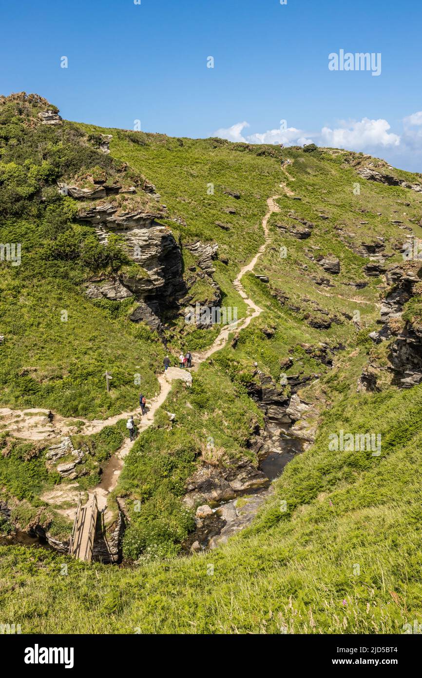 Wanderer klettern den Abschnitt Rocky Valley des South West Coast Path Tintagel Cornwall England Großbritannien Stockfoto