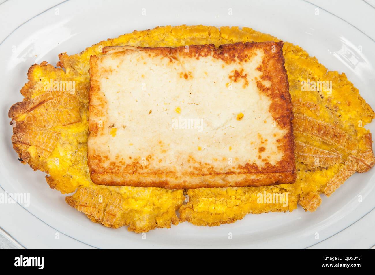 Gebratener Wegerich toston (Patacon) mit gebratenem Käse. Stockfoto