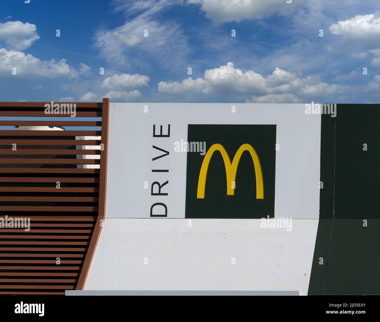 Savigliano, Italien - 16. Juni 2022: McDrive-Schild am neuen McDonald's ristorante am blauen Himmel bewölkt. Die McDonald's Corporation ist die größte Kette der Welt Stockfoto