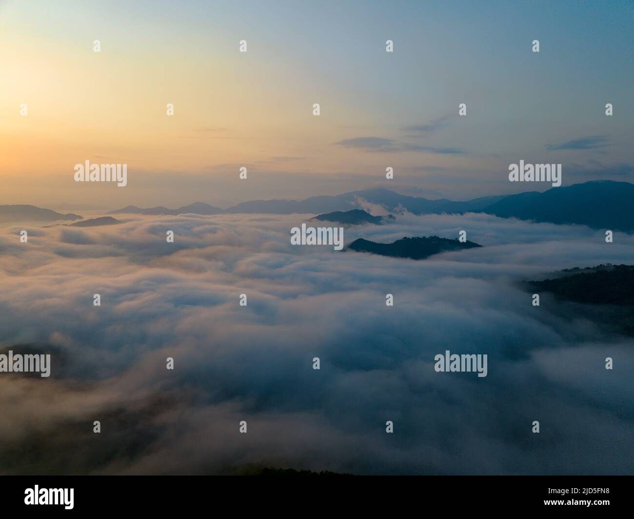 Sonnenaufgang über dem Meer aus Wolken und Berggipfeln Stockfoto