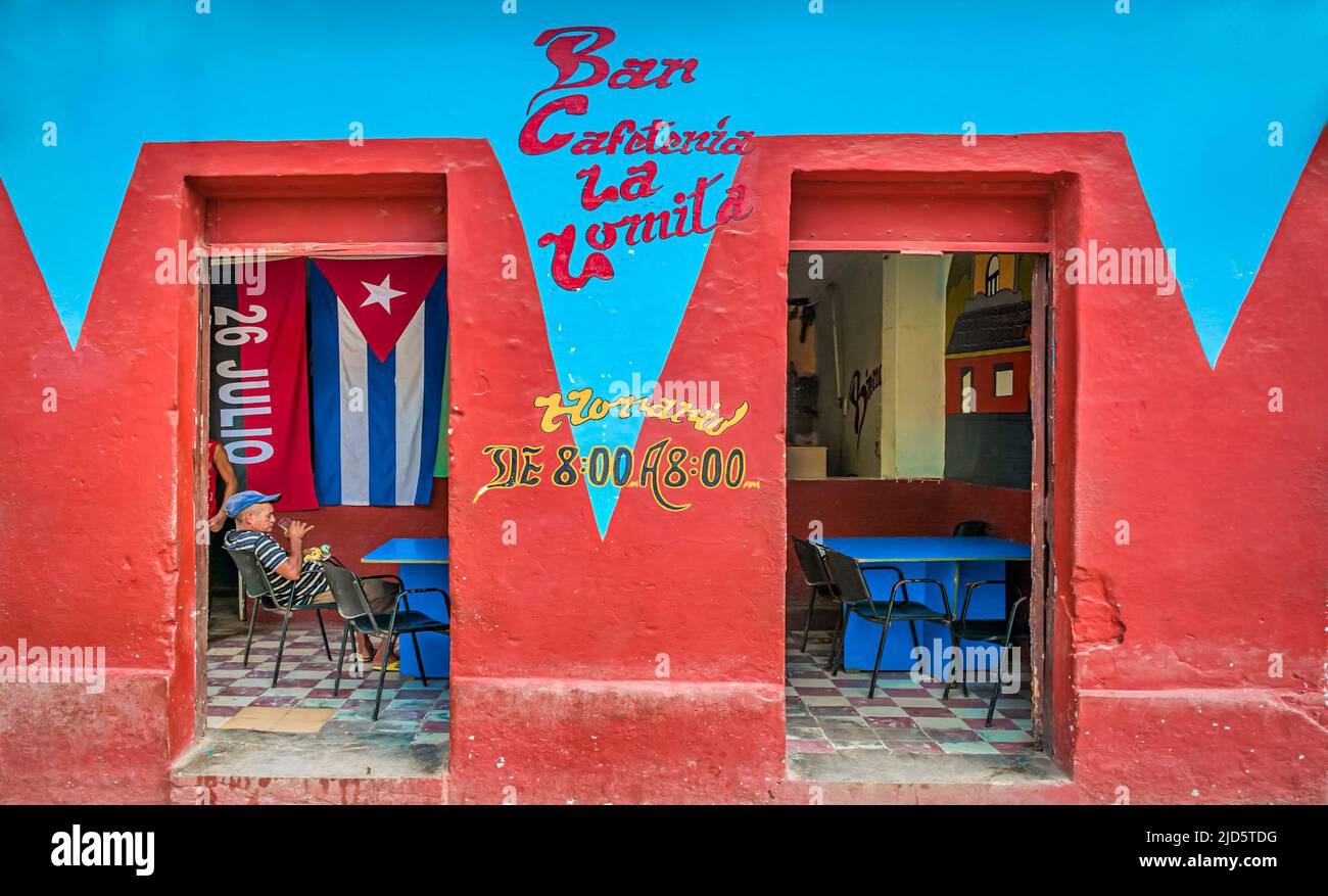 Rot und blau gestrichene Bar mit kubanischer Flagge im Inneren und einem alten Mann im Inneren in Trinidad, Kuba Stockfoto