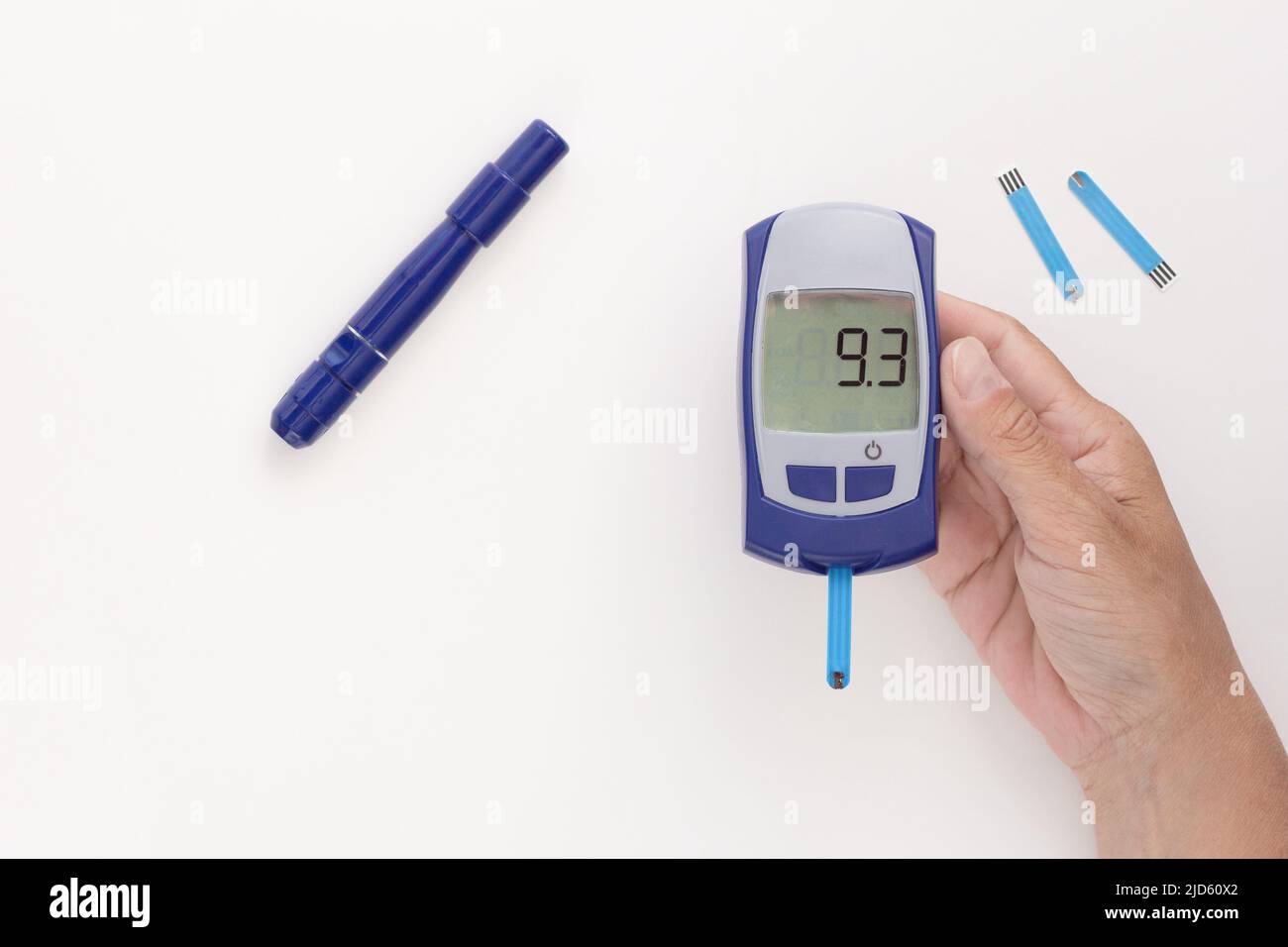 Draufsicht auf eine zugeschnittene Frauenhand mit Glucometer mit neun Punkten drei 9,3 mmol pro Liter glykämischem Index auf dem Display mit blutigem Teststreifen im Inneren, l Stockfoto
