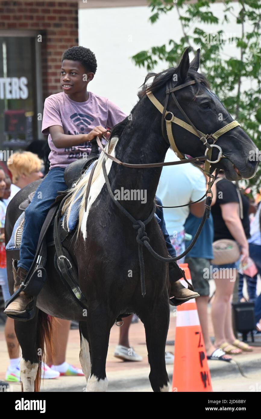 Zebulon, NC, USA, 18.. Juni 2022, afroamerikanische Cowboys ziehen zu Pferd durch die Innenstadt von Zebulon im Rahmen einer wochenlangen Feier der Befreiung von der Sklaverei. Der 2021. Juni ist ein Bundesfeiertag zum Gedenken an die militärische Ankündigung vom 19 1865. Juni, die die Freiheit für versklavte Menschen in Galveston, Texas, proklamiert. Viele Sklaven in Texas waren sich der Emanzipationsproklamation von Präsident Lincoln aus dem Jahr 1863 nicht bewusst, die sie zwei Jahre zuvor aus der Sklaverei befreite, und Sklaven in Galveston waren die letzten, die die Nachrichten hörten. Credit D Guest Smith / Alamy Live News Stockfoto