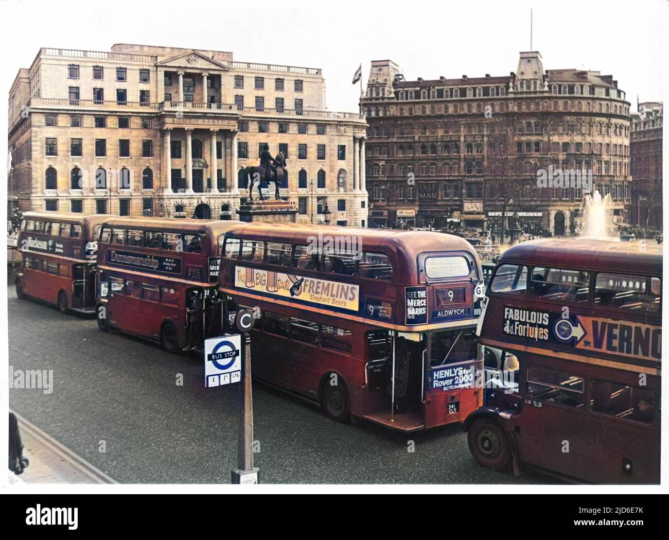 Vier Londoner „Routemaster“-Busse stehen auf der Seite der National Gallery am Trafalgar Square in einer Warteschlange, wobei die südafrikanische Botschaft im Hintergrund steht. Kolorierte Version von : 10083083 Datum: Ende 1960s Stockfoto