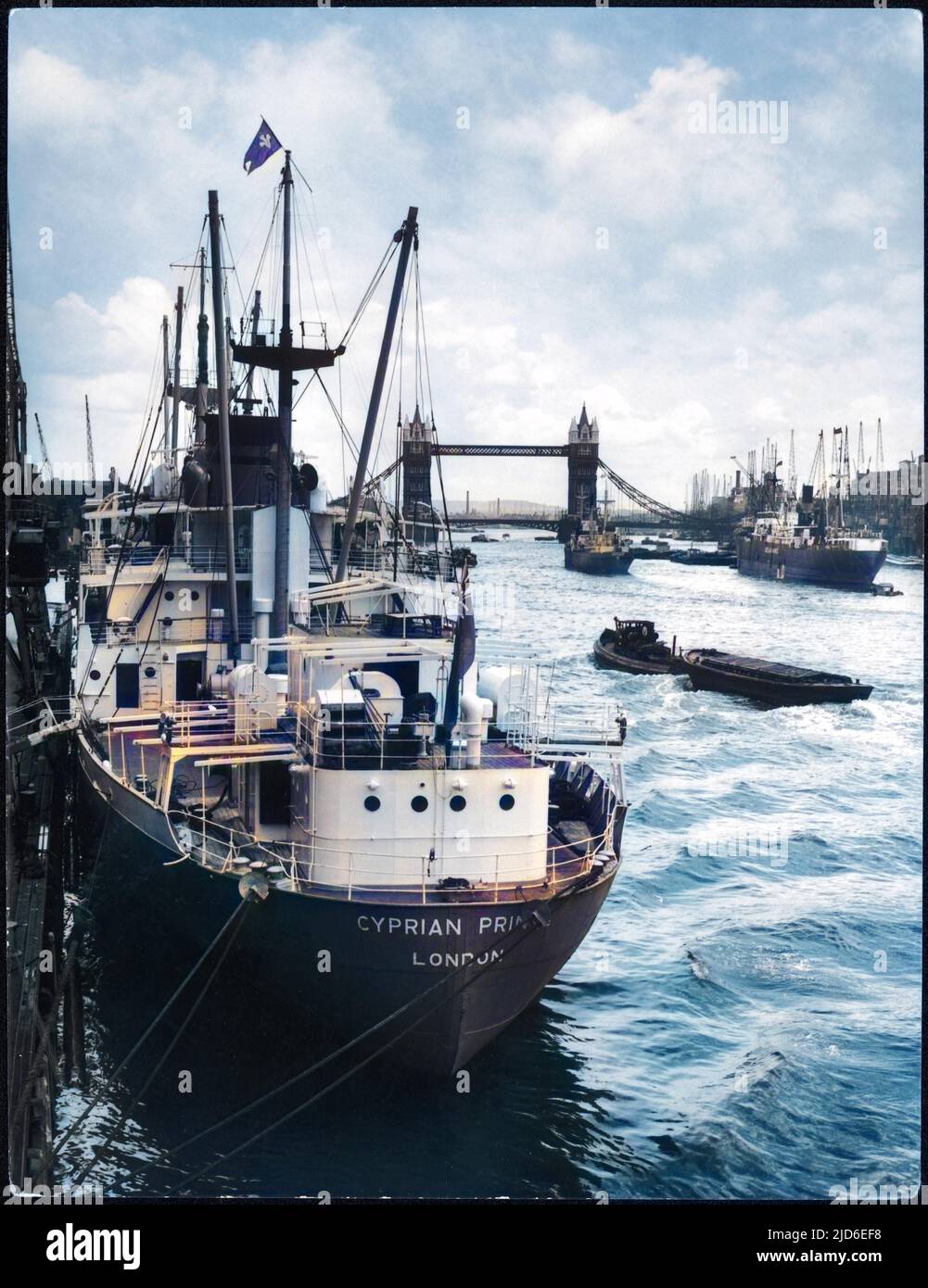 Eine geschäftige Szene auf der Themse im Pool von London zwischen London Bridge und Tower Bridge; ein Schiff (Cyprian Prince ?) Ist am Flussufer vertäut Colorized Version von : 10120633 Datum: 1950s Stockfoto