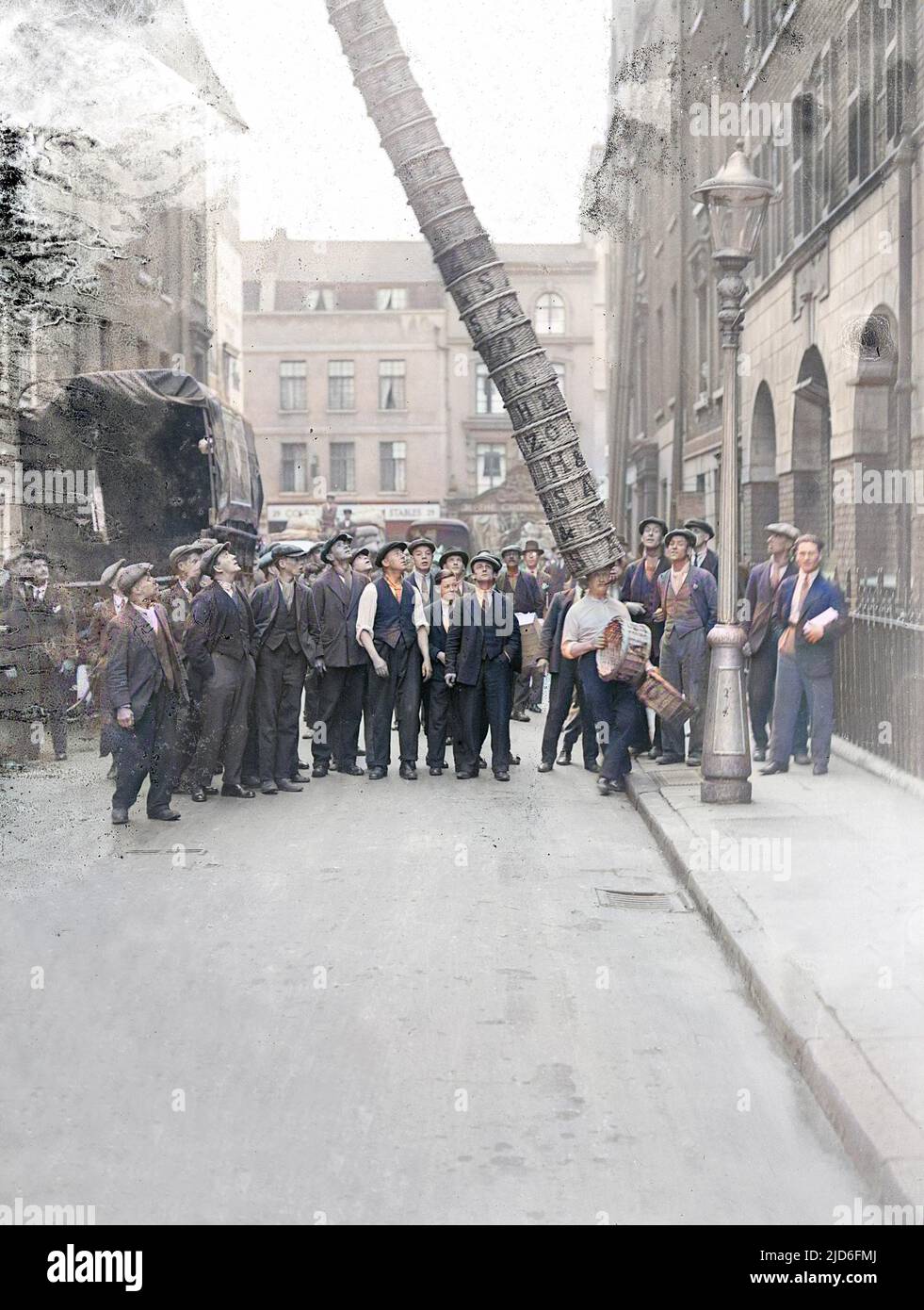 Ein Champion-Korbträger in Covent Garden, London, verliert die Kontrolle über seinen Korbturm - Schau mal rein! Kolorierte Version von : 10165265 Datum: Anfang 1930s Stockfoto