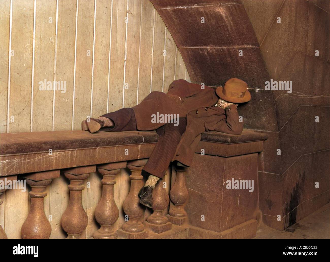 Ein Landstreicher (oder einfach nur ein obdachloser junger Mann), der auf dem Embankment, London, England, hart schläft. Kolorierte Version von : 10168261 Datum: Anfang 1930s Stockfoto