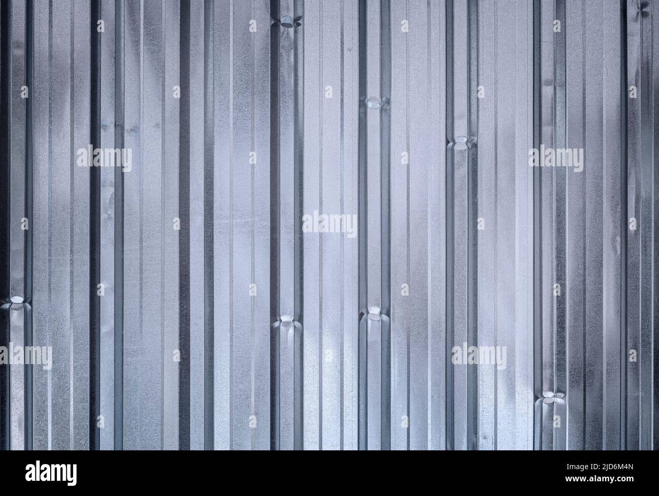 Glänzende, gewellte, verzinkte Metallwand, Vorderansicht. Blauer Metallic-Farbton. Hochauflösender, strukturierter, abstrakter Hintergrund im Vollformat. Speicherplatz kopieren. Stockfoto