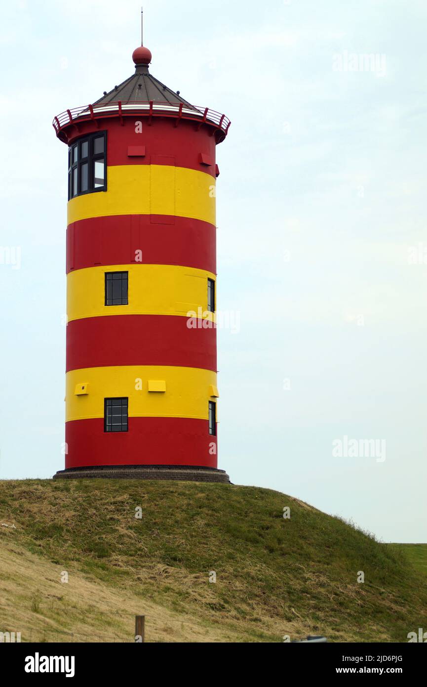 Süßer deutscher Leuchtturm in rot und gelb. Er wurde 1891 gebaut und ist 11 Meter hoch. Es ist bekannt als der Leuchtturm von Pilsum Stockfoto