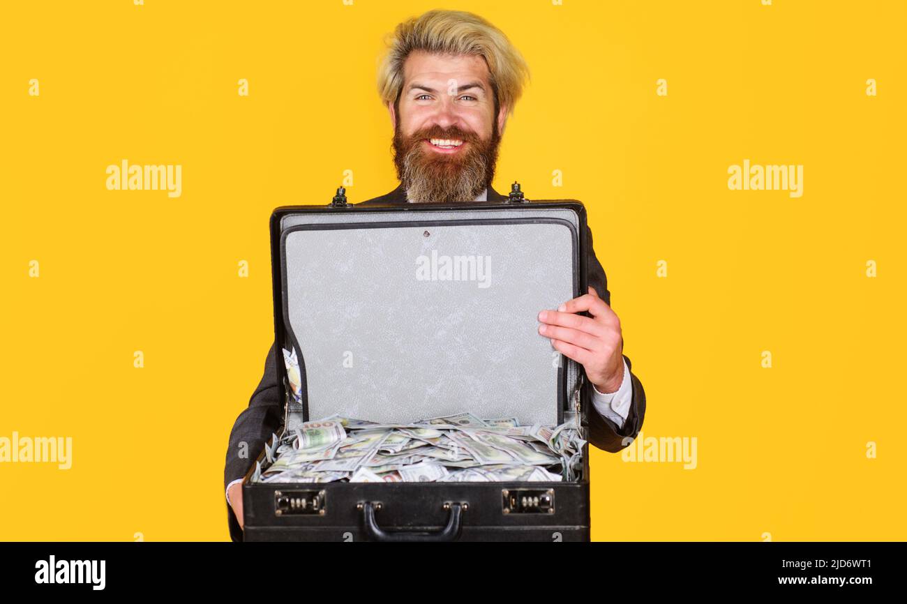 Geschäftserfolg. Lächelnder Geschäftsmann mit Aktentasche voller Geld. Leihservice. Reichtum und Reich. Stockfoto