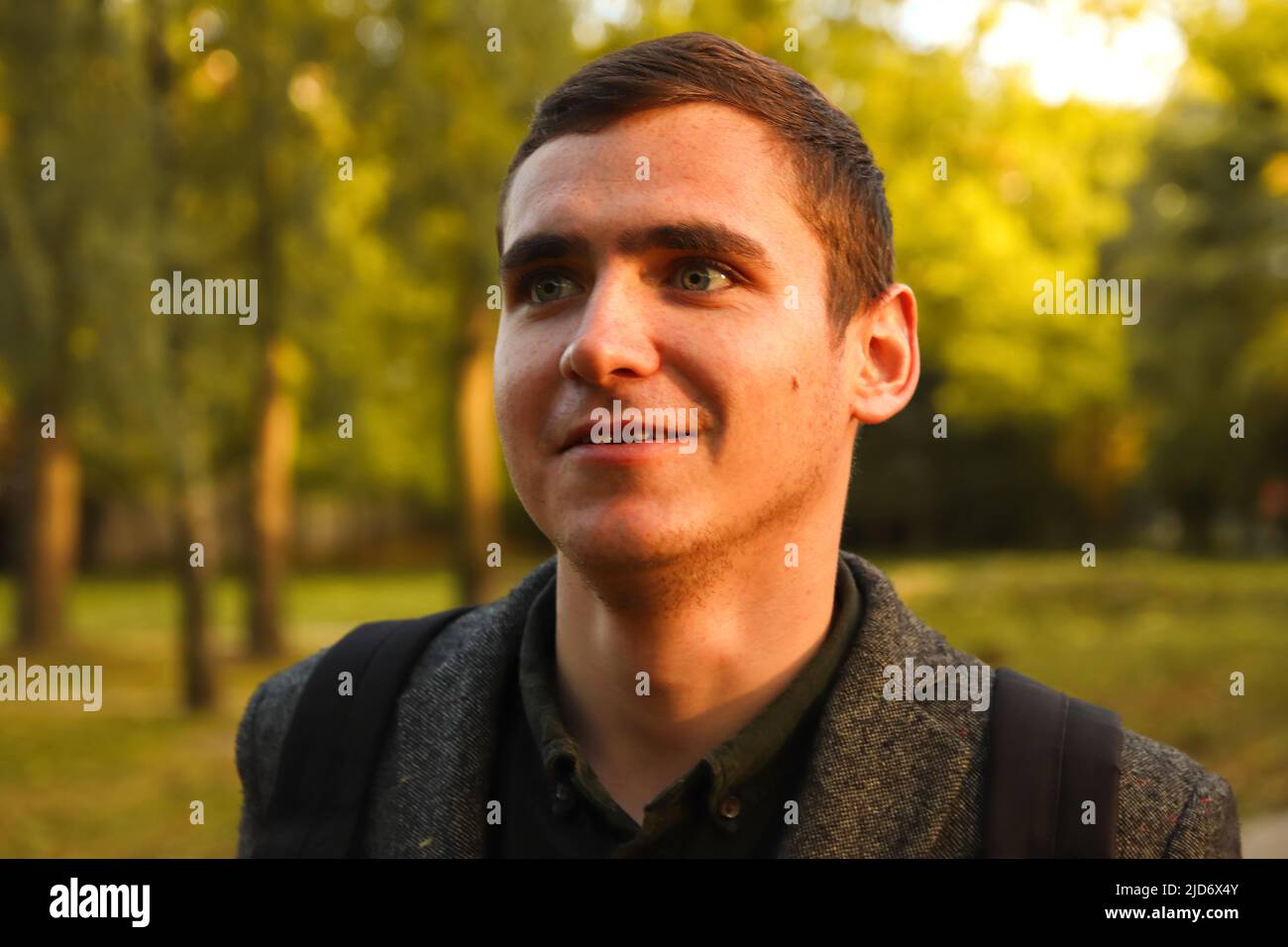Portrait junger Mann auf Natur Herbst Hintergrund. Lächelnder junger Mann. 20s Jahre. Schöner Mann im Freien Porträt. Spaziergang im Park. Lifestyle Stockfoto