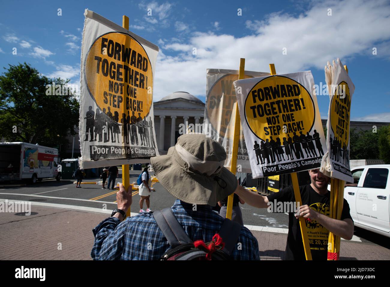 Ein Freiwilliger überreicht am 18. Juni 2022 Protestschilder an Neuankömmlinge der Versammlung der Armen und Niedriglohnarbeiter in Washington, DC. Unter der Leitung von Rev. William J. Barber II versammelten sich Tausende in der Nähe des US-Kapitols, um „die Übel des systemischen Rassismus, der Armut, der Kriegsökonomie, der ökologischen Verwüstung und der verzerrten moralischen Erzählung des religiösen Nationalismus der Nation herauszufordern“. (Foto: Alejandro Alvarez/Sipa USA) Quelle: SIPA USA/Alamy Live News Stockfoto