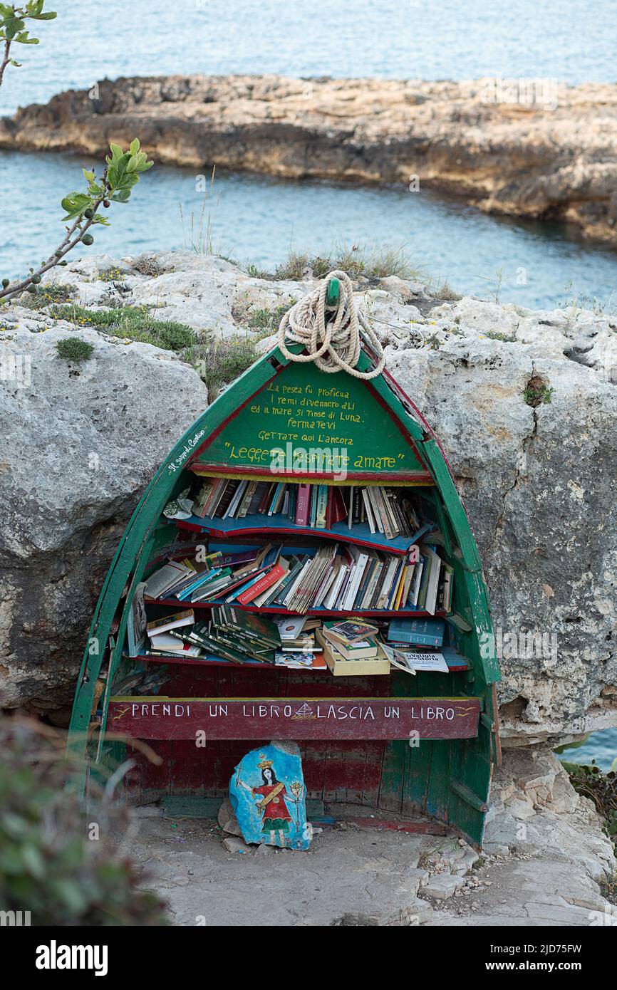 Lecce, Italien - april 2022, Freie Bibliothek auf Holzboot mit Büchern auf Felsen in der Nähe des Meeres für touris Stockfoto