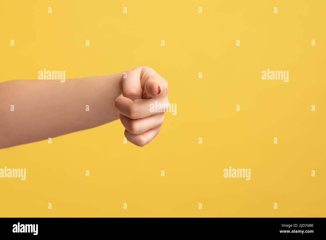 Nahaufnahme Profil Seitenansicht der Frau Hand Finger zeigt Richtung zur Kamera, wählen Sie. Innenaufnahme des Studios isoliert auf gelbem Hintergrund. Stockfoto