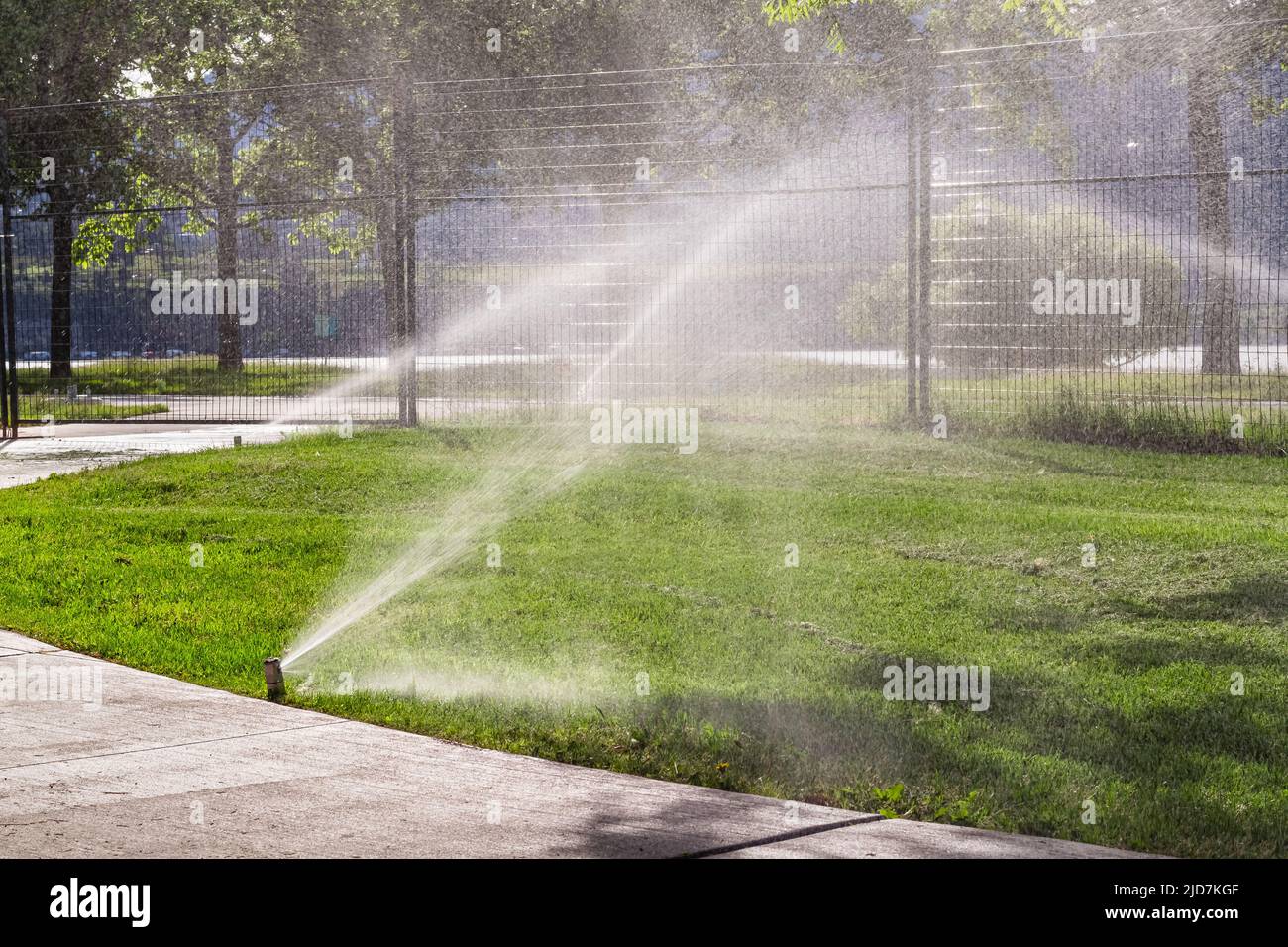 Automatische Sprinkler zur Bewässerung von Gras Bewässerungssysteme Für Den Garten. Bewässerungssystem Bewässerung des grünen Grases. Bewässerung der Sprinkleranlage im Wohngebiet Stockfoto