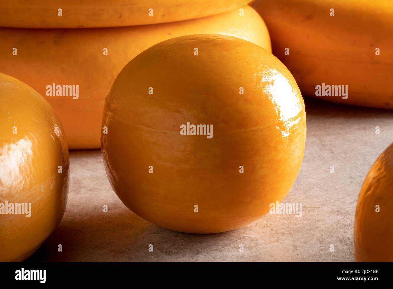 Ein einziger holländischer Edam-Käse aus der Nähe zwischen anderen Käsesorten Stockfoto