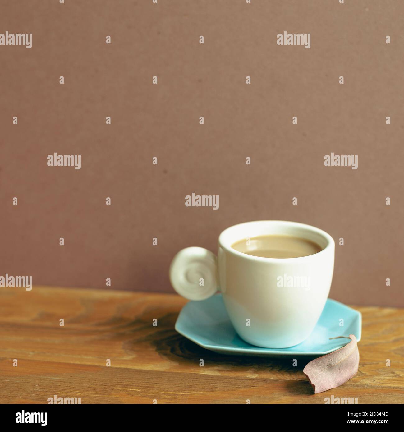 Tasse Kaffee auf Holztisch. Brauner Wandhintergrund Stockfoto
