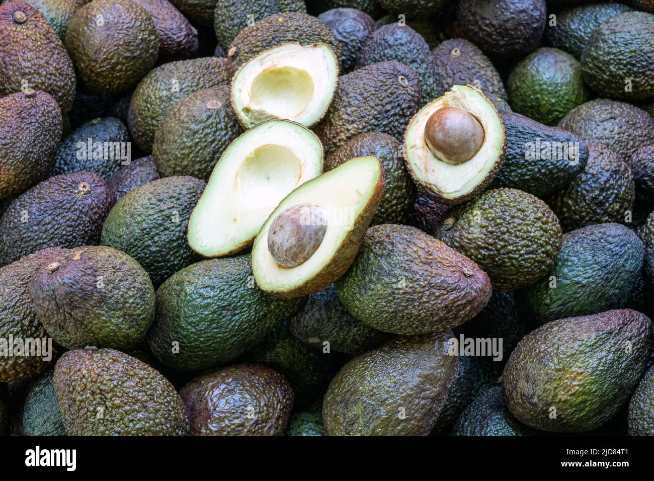 Avocados zum Verkauf auf einem Markt mit zwei halbgefütterten Stockfoto