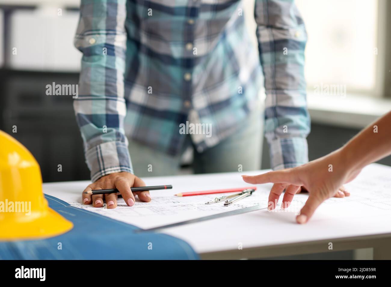 Architekt diskutiert Projekt mit Kollegen anhand von Bauplänen Stockfoto