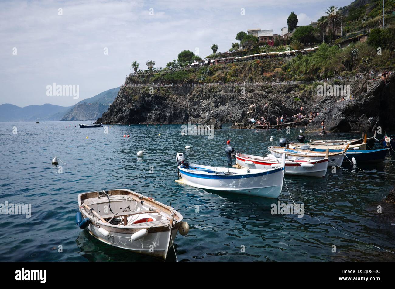 Manarola, Ligurien, Italien - 2022. Mai: Kleine Motorboote liegen in der Bucht des Nationalparks Cinque Terre an der italienischen Riviera. Motorboote, die festgemacht wurden Stockfoto