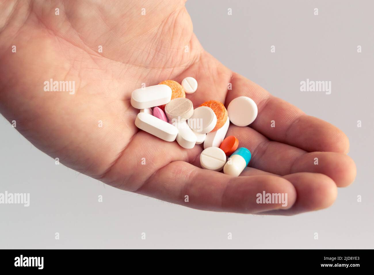 Nahaufnahme der Hand mit bunten Pillen. Medizin und Gesundheitskonzept. Gesunde Lebensweise, Medizin, Nahrungsergänzungsmittel und Menschen Konzept Stockfoto