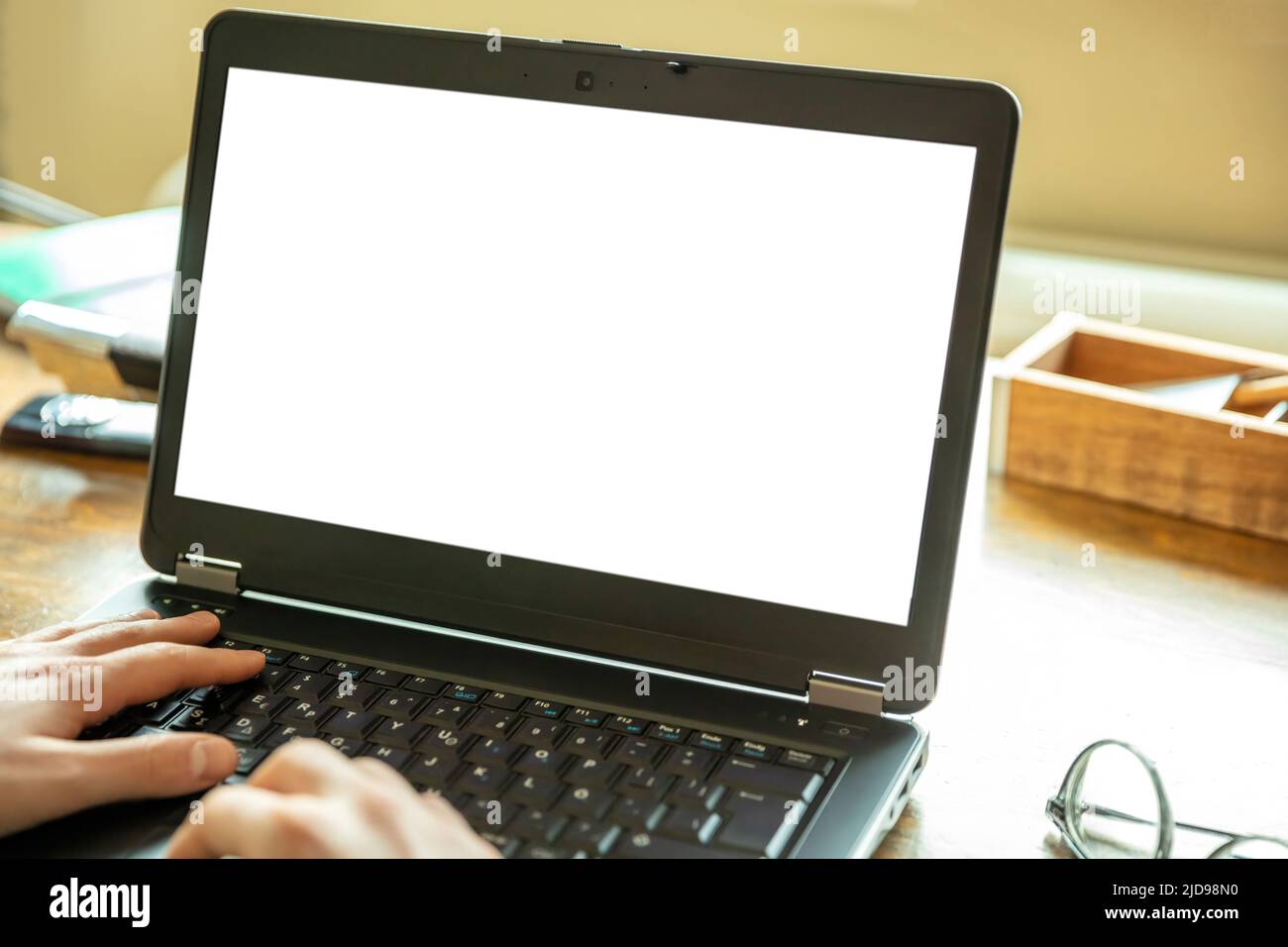 Computerbildschirmmockup. Laptop offen mit weißem leeren Bildschirm auf einem Holzschreibtisch, Bürohintergrund, Kopierraum, Präsentationsvorlage bewerben Stockfoto