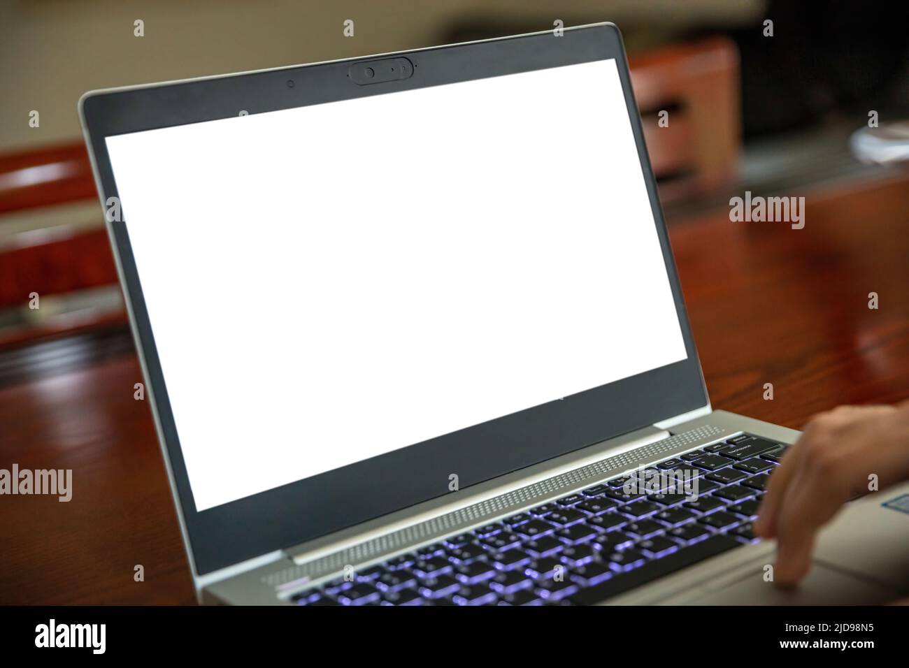 Laptop offen mit weißem leeren Bildschirm auf einem Holzschreibtisch, Bürohintergrund, Kopierraum, Präsentationsvorlage bewerben. Computerbildschirmmockup. Stockfoto