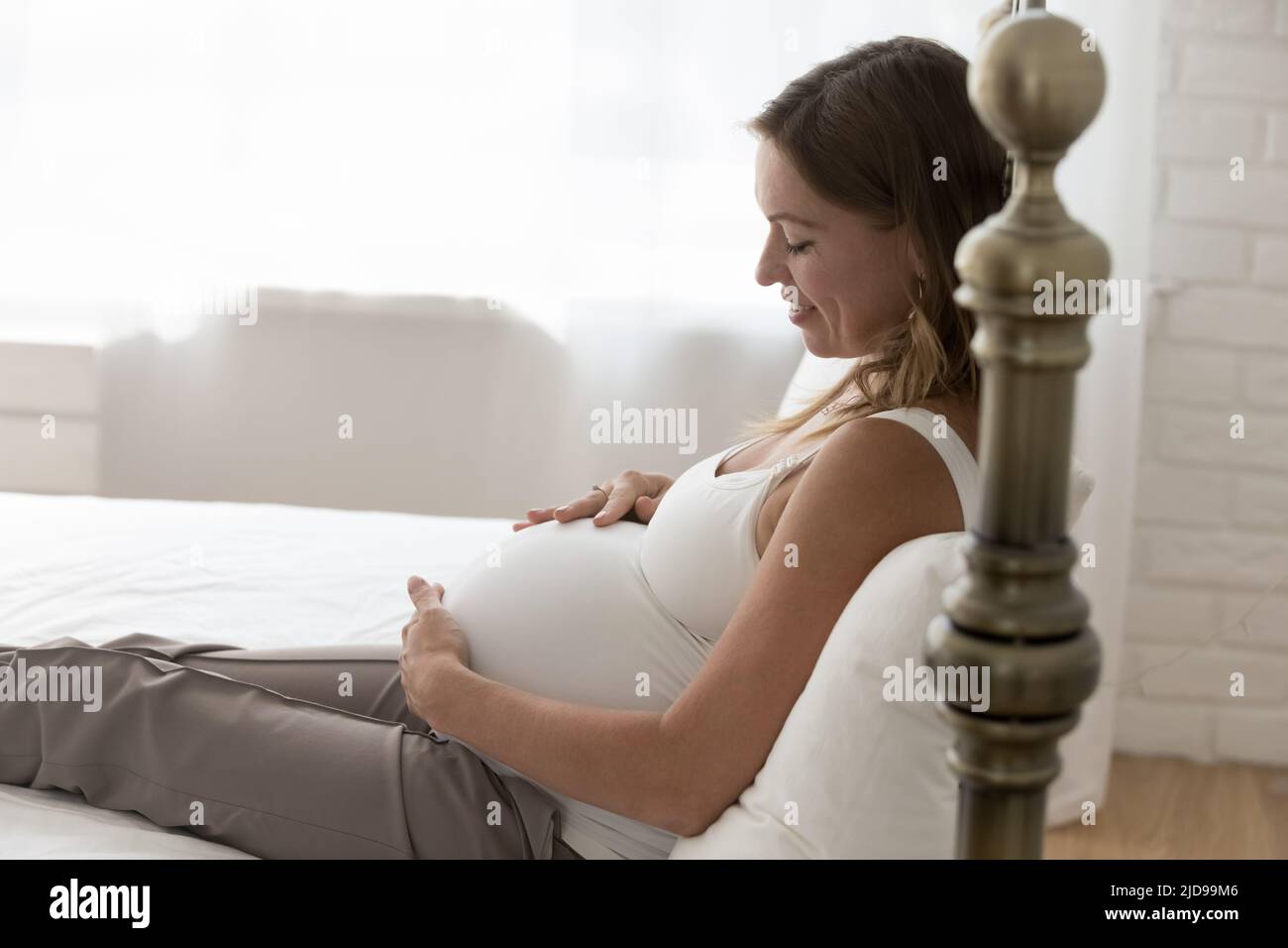 Junge, schwanger Frau berührt ihren großen Bauch und fühlt sich verliebt Stockfoto