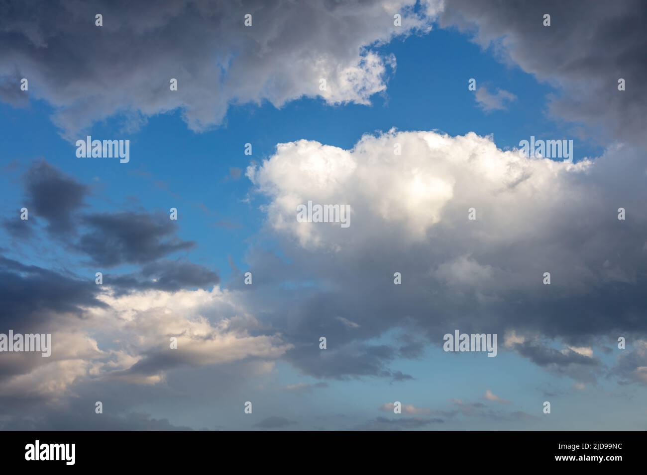 Regenwolke auf blauem Himmel Hintergrund. Flauschige Cumulus-Wolkenlandschaft in weißer und grauer Schattierung. Wetter, Meteorologie Konzept Stockfoto