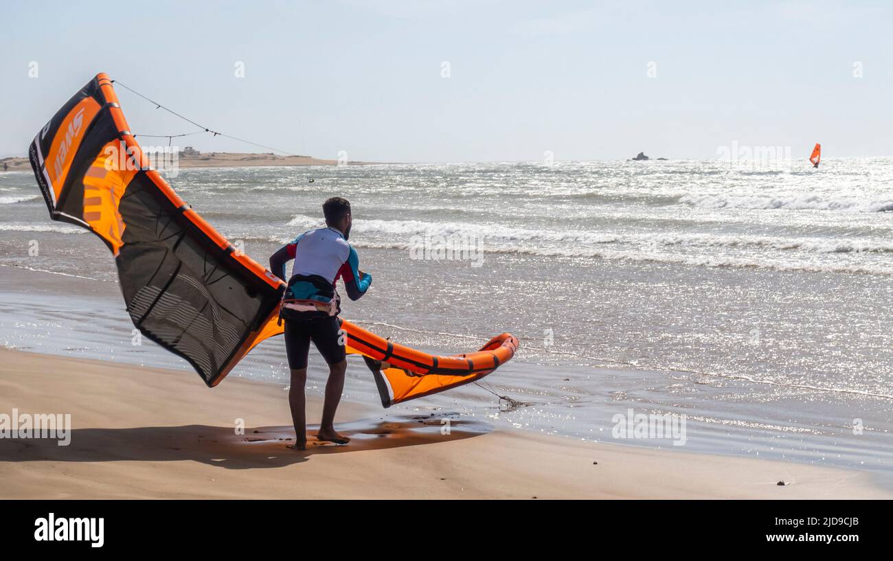 Kitesurfer, der seinen Kite bei starkem Wind an der Atlantikküste im Hafen von Essaouira, Marokko, verwaltet Stockfoto