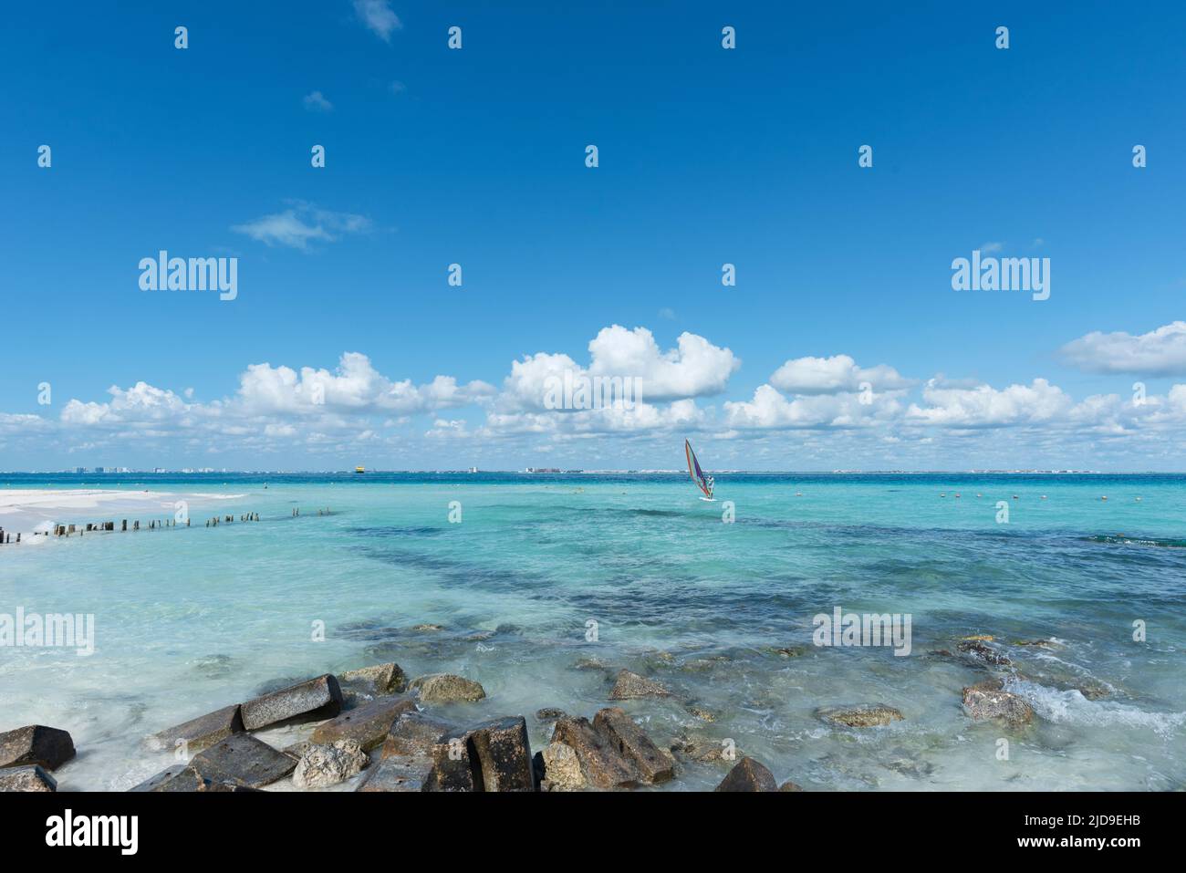 Mann auf einer Windsurf in der Nähe eines Strandes in Isla Mujeres, Mexiko, gegen den blauen Himmel während der Sommerferien Stockfoto