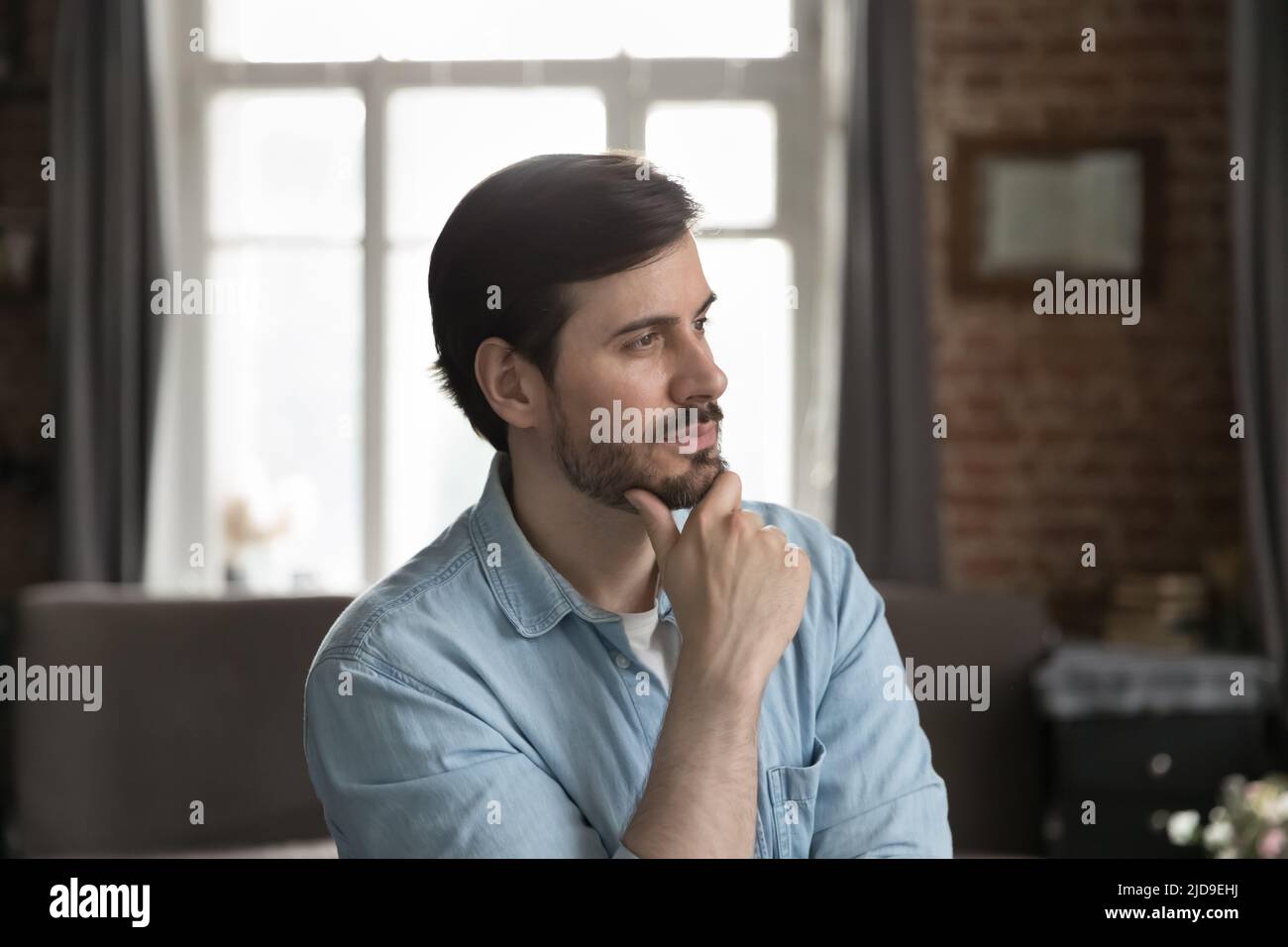 Ernsthaft nachdenklicher Mann, der in Distanz schaut und denkt Stockfoto