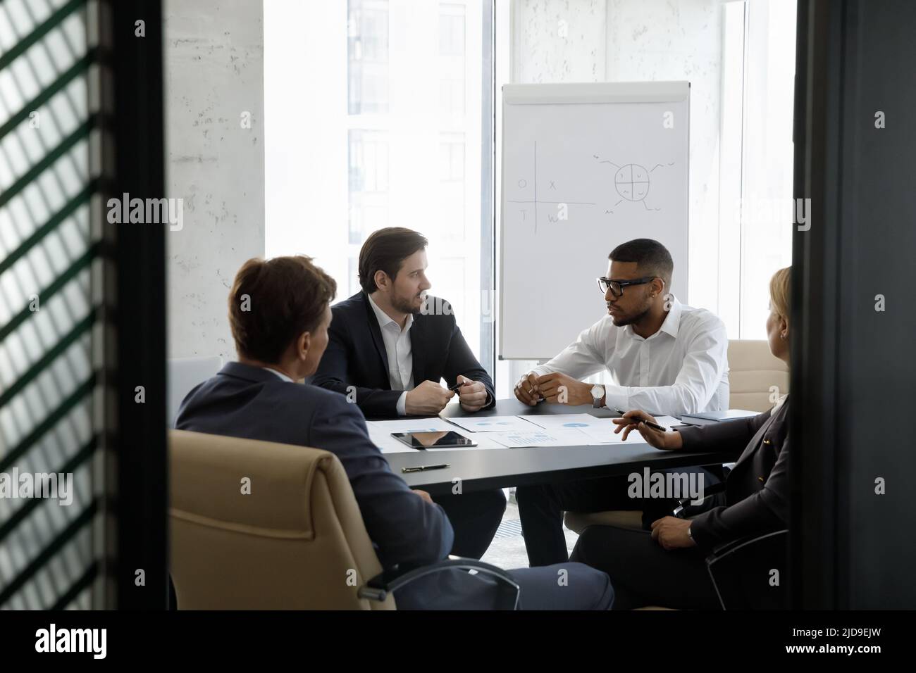 Eine Gruppe von seriös multirassischen Geschäftsleuten, die verhandeln, lösen die Geschäfte im Sitzungssaal Stockfoto