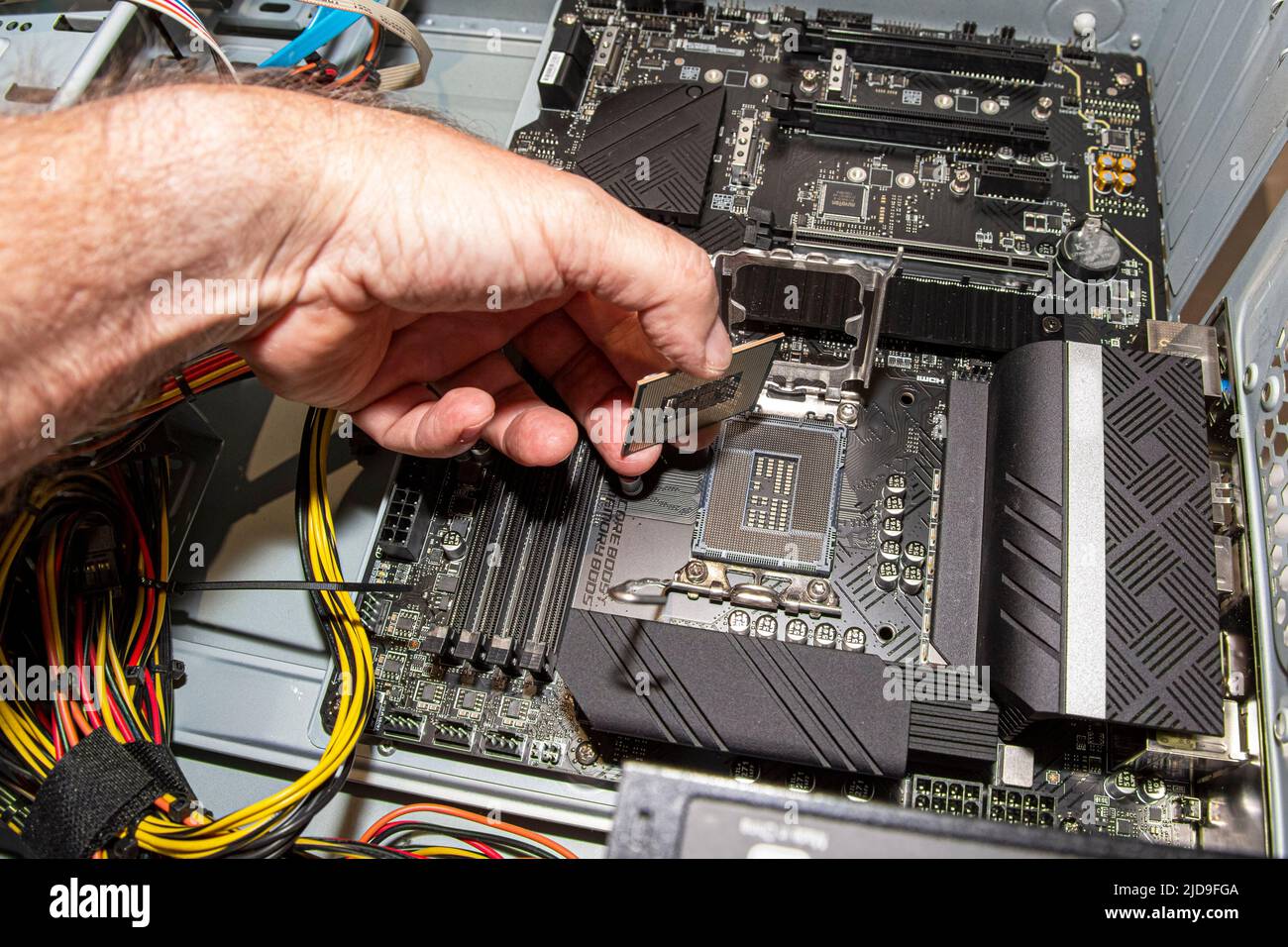 Ein Systemadministrator montiert einen Prozessor auf einer Hauptplatine des Computers Stockfoto