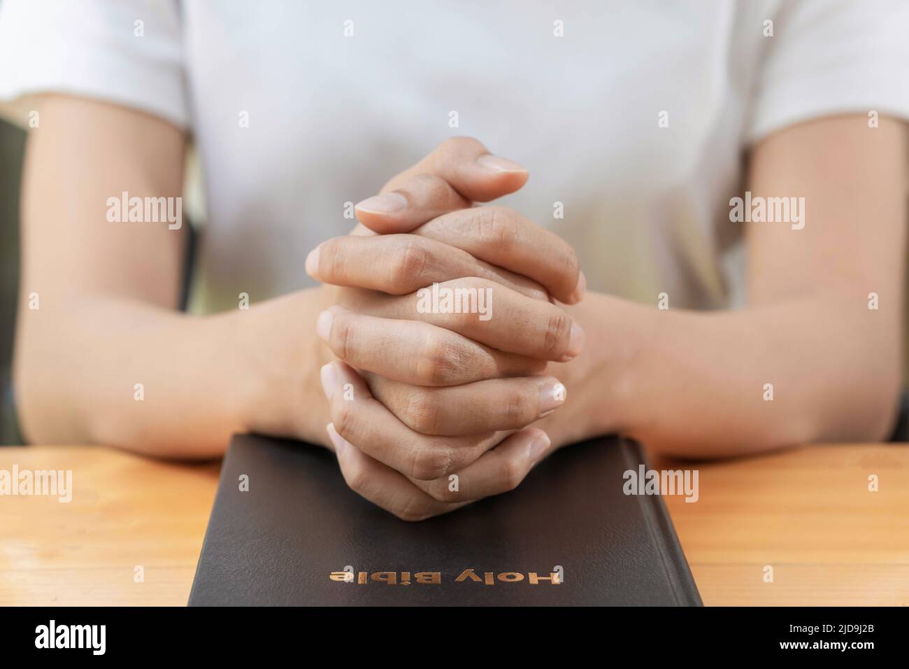 Beten und Religion Konzept, weibliche christliche Hände gefaltet auf der heiligen bibel zum Gebet für Spiritualität Stockfoto