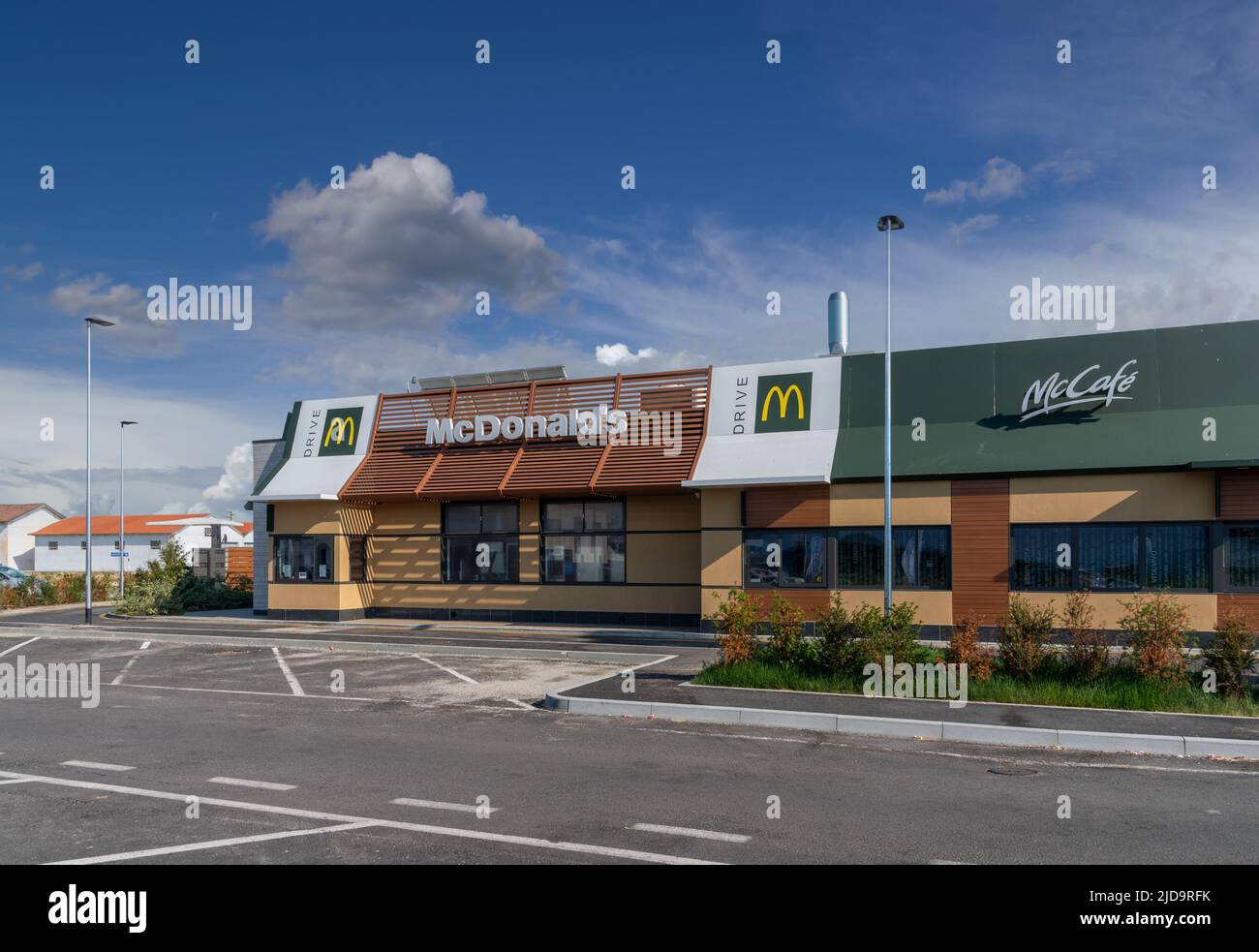 Savigliano, Italien - 16. Juni 2022: McDonald's-Restaurant mit Mc Drive am wolkenblauen Himmel. Die McDonald's Corporation ist die weltweit größte Kette von hamb Stockfoto