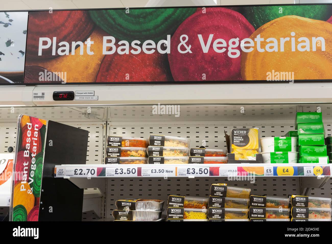 Pflanzenbasierte und vegetarische Schilder- und Lebensmittelprodukte in Supermarktregalen in Tesco, Großbritannien Stockfoto