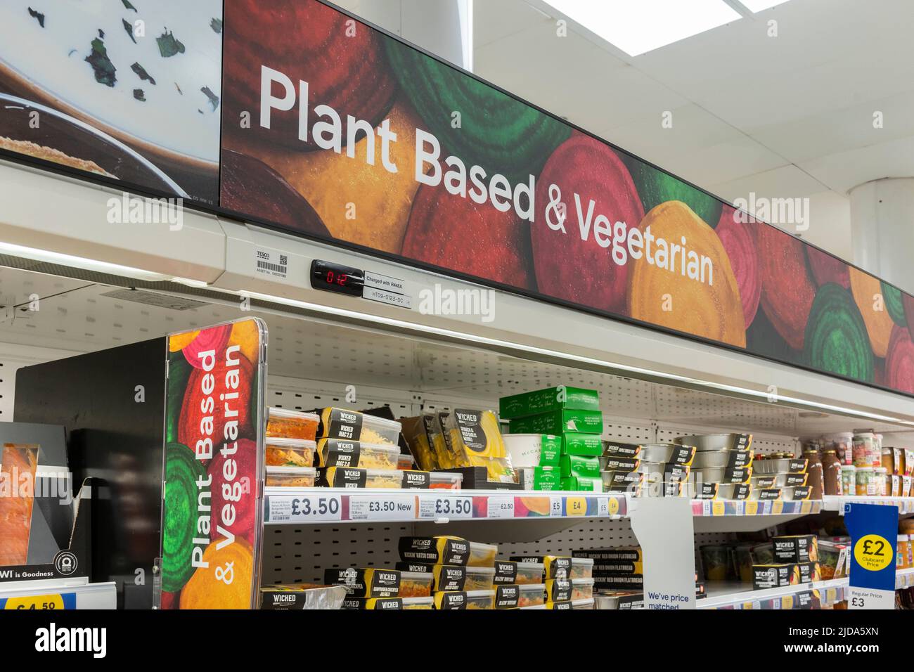Pflanzenbasierte und vegetarische Schilder- und Lebensmittelprodukte in Supermarktregalen in Tesco, Großbritannien Stockfoto
