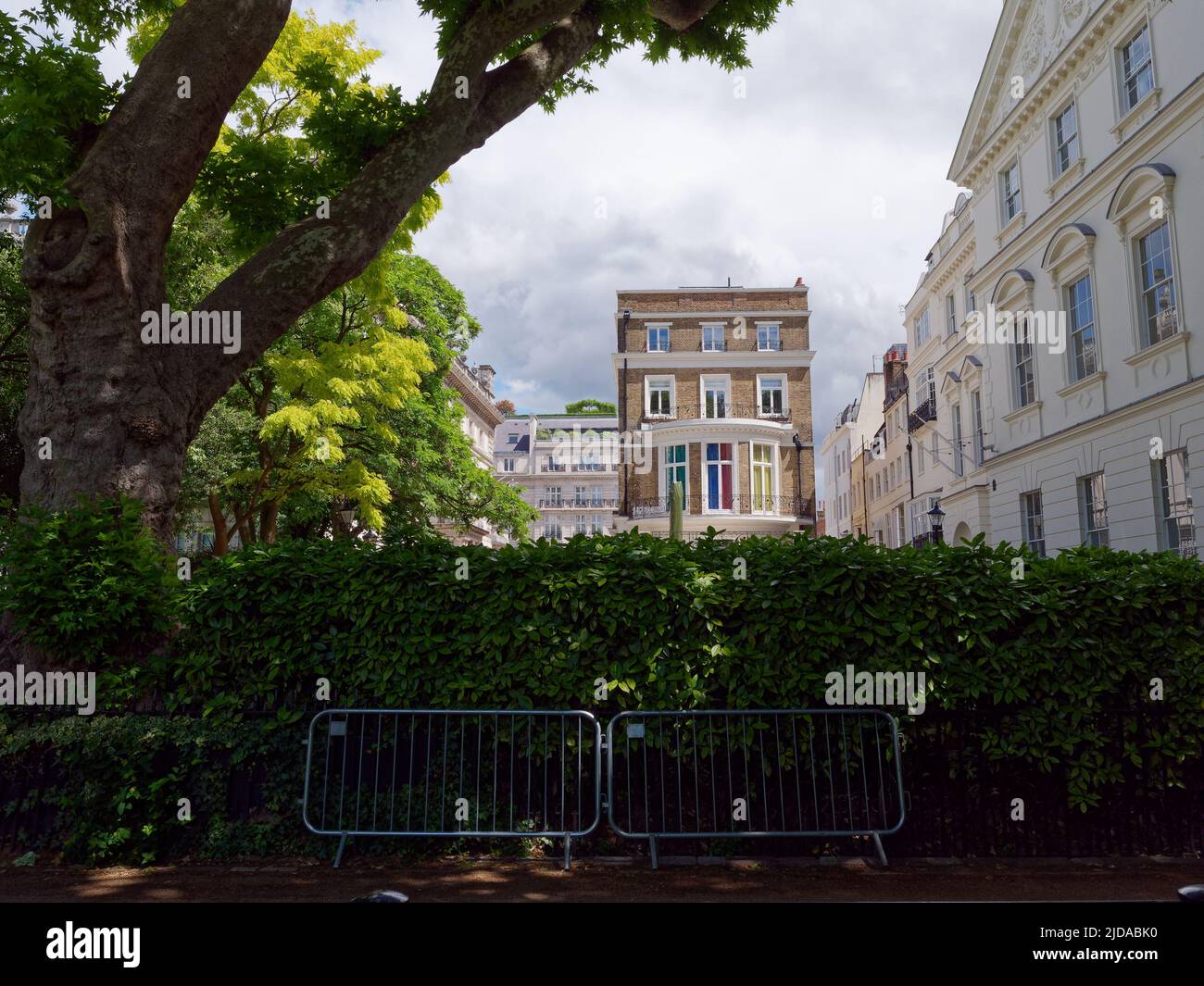 London, Greater London, England, Juni 08 2022: Immobilien gegenüber dem Green Park mit einem Baum, einer Hecke und einer Barriere davor. Stockfoto