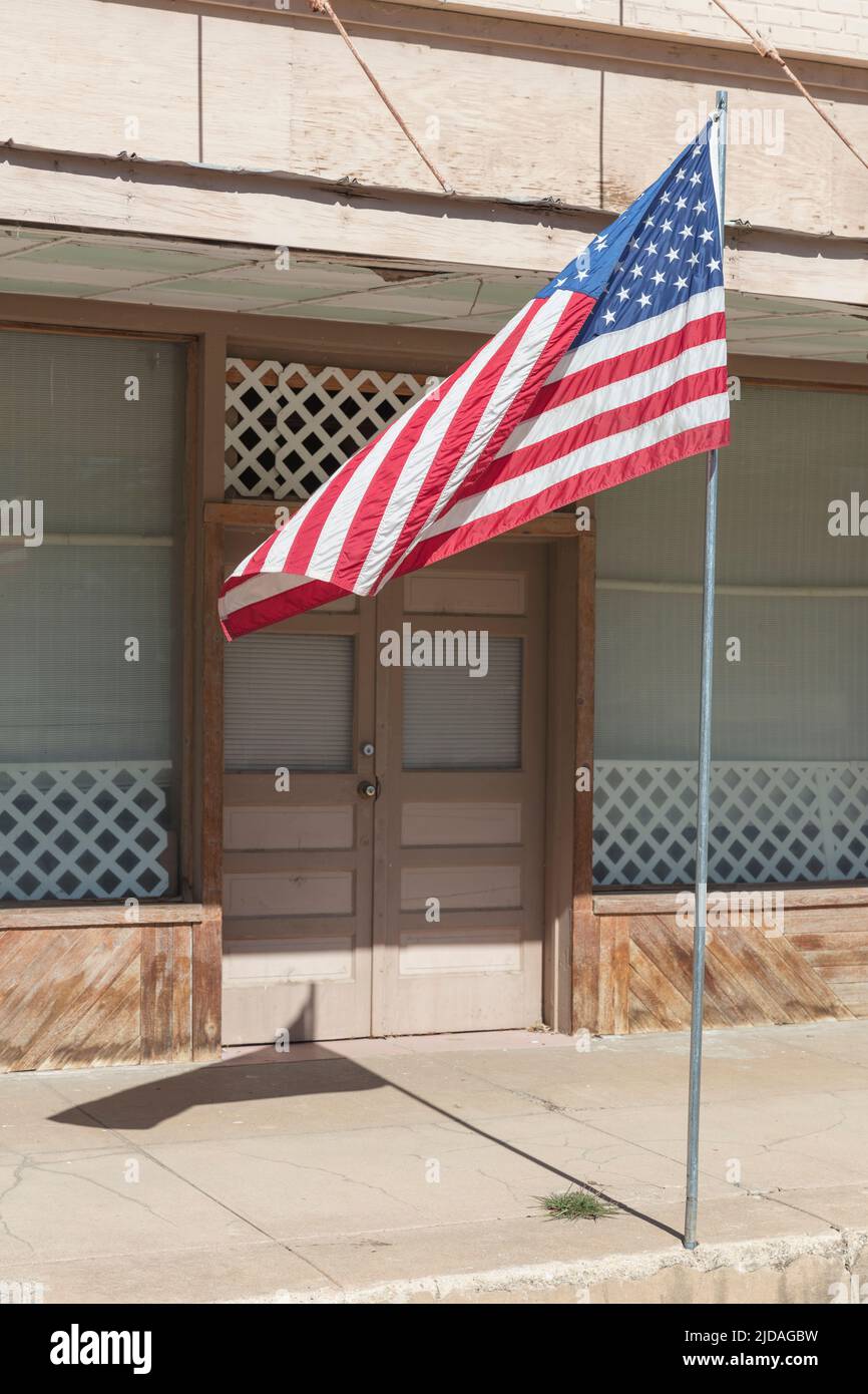 Amerikanische Flagge, die vor einem Gebäude an einer Hauptstraße fliegt. Stockfoto