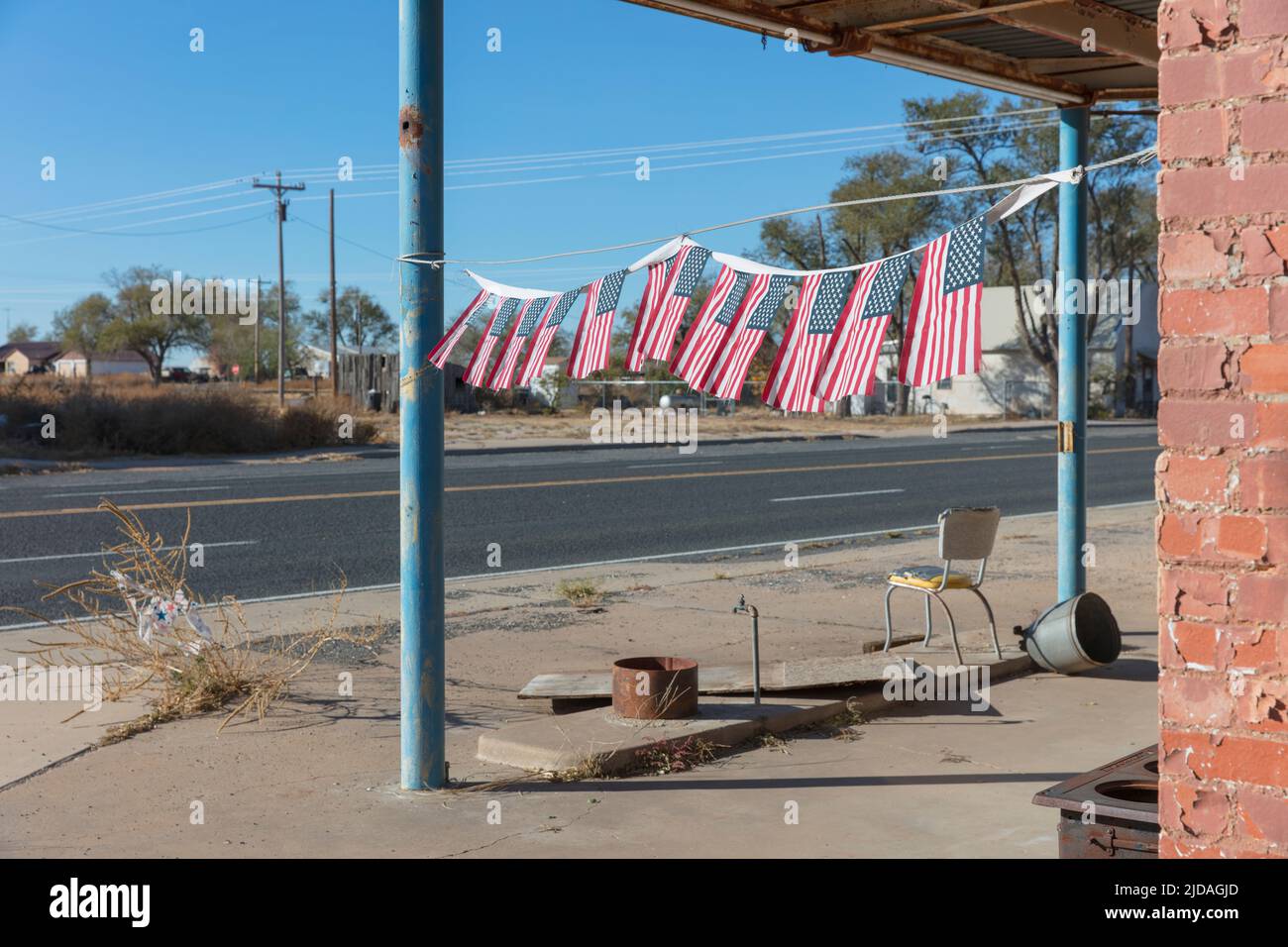 Amerikanische Flaggen vor einer verlassenen Tankstelle. Stockfoto
