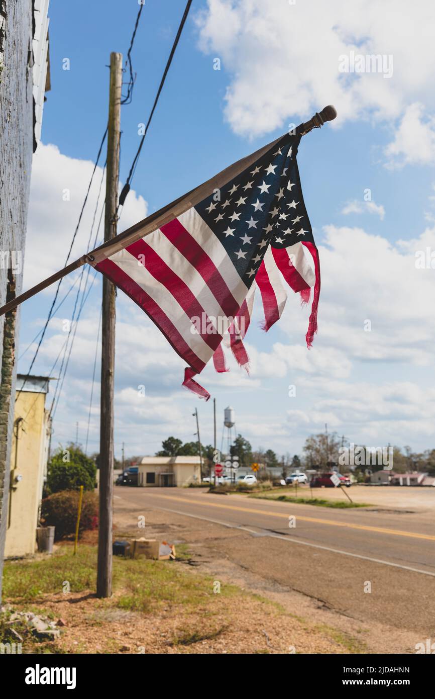 Zerfetzte amerikanische Flagge, die auf einem Gebäude an der Main Street fliegt. Stockfoto