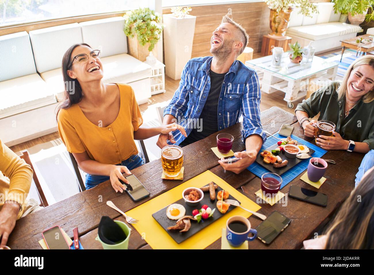 Eine Gruppe von Freunden, die im Restaurant zu Mittag essen. Fröhliche junge Leute essen Burger und genießen in einem Fast-Food-Restaurant. Stockfoto