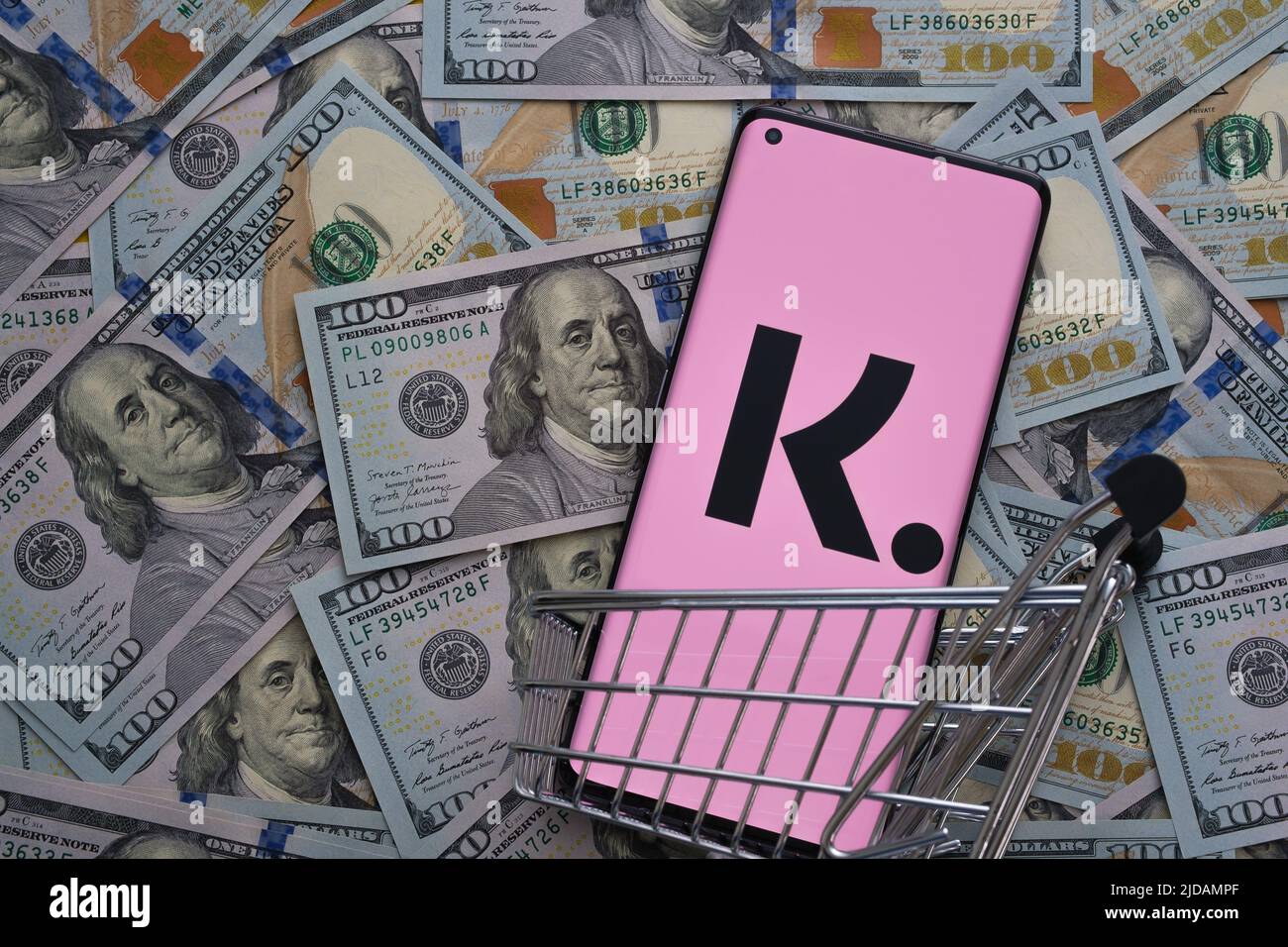 Klarna App-Logo auf dem Bildschirm des Smartphones auf Dollarscheine platziert gesehen. Konzept für Credit App. Stafford, Großbritannien, Juni 19 2022 Stockfoto